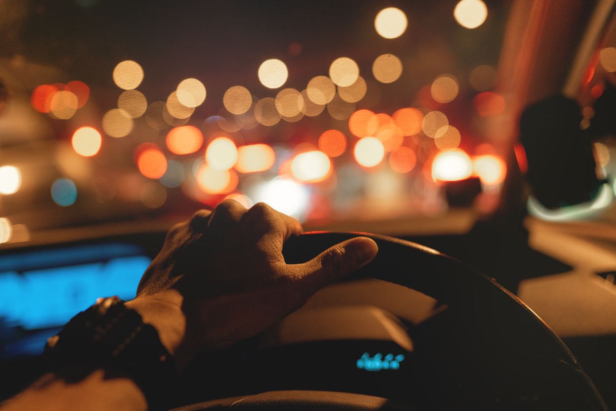 hand on steering wheel while driving at night